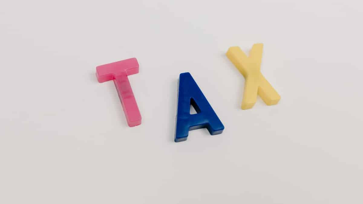 Colorful plastic letters spelling tax on a clean white background.