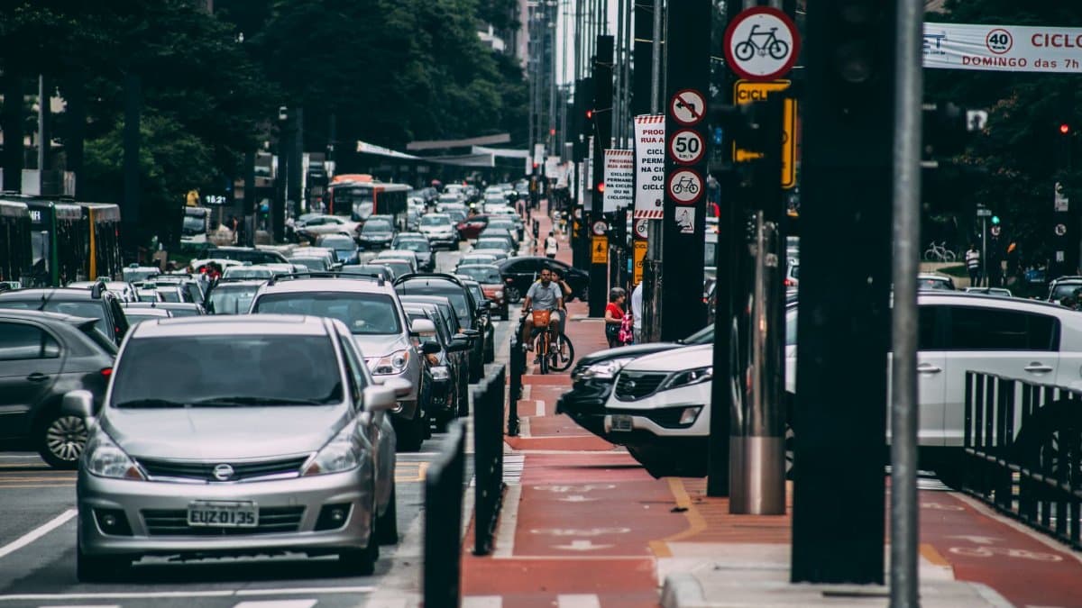 Urban street scene with heavy traffic and cyclists in a bustling city environment.