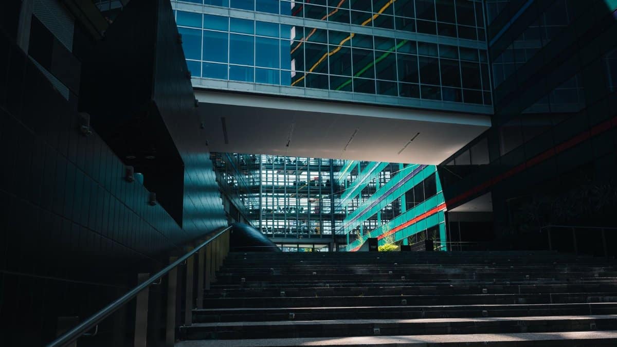 Stylish modern architecture of a glass office building with steps in an urban downtown setting.