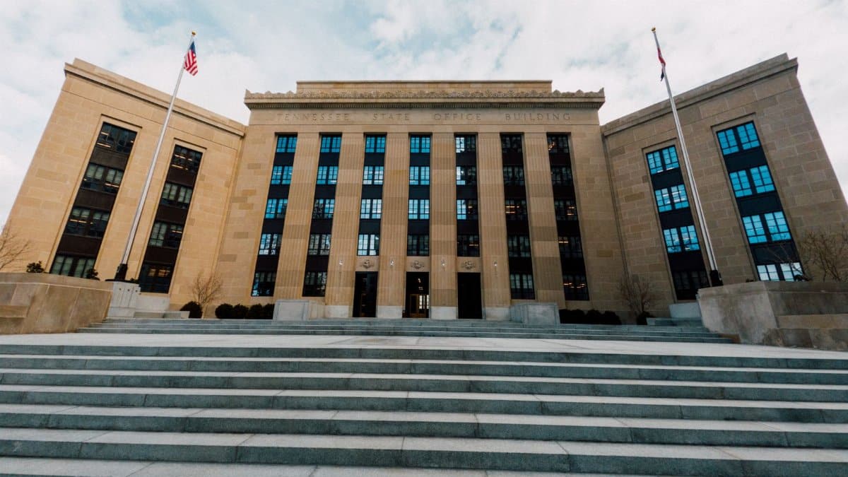 From below of Federal Reserve building exterior against USA flags and staircase under cloudy sky in town