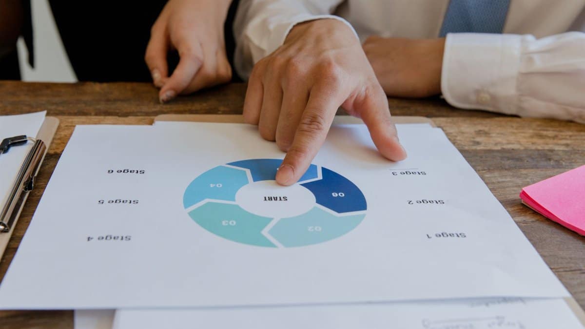 Close-up of hands pointing to a circular business strategy plan on paper.