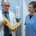 Doctors and nurses in consultation over patient records within a hospital setting.