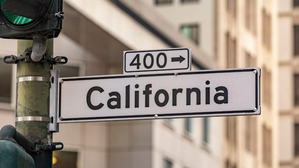 Street sign for California with traffic light in cityscape. Urban navigation and signage theme.