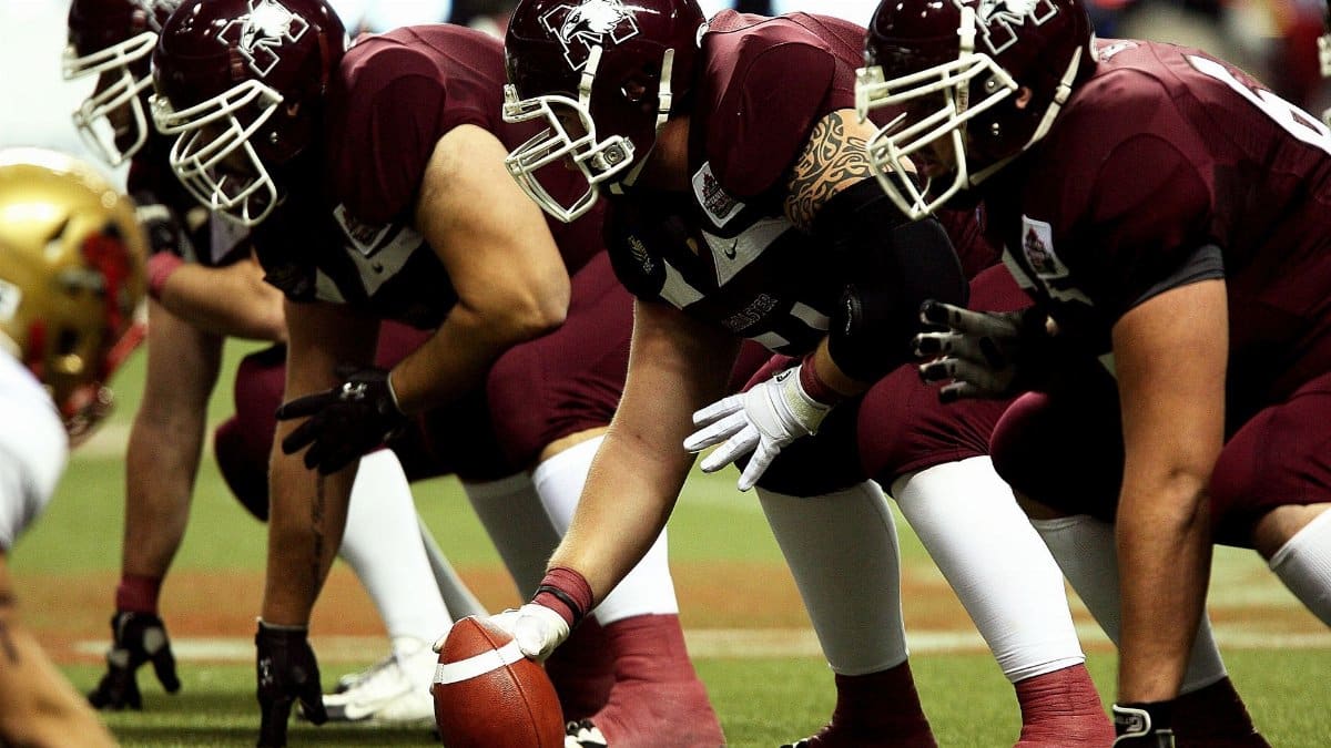 Dynamic shot of American football players in formation on the field, ready to start the game.