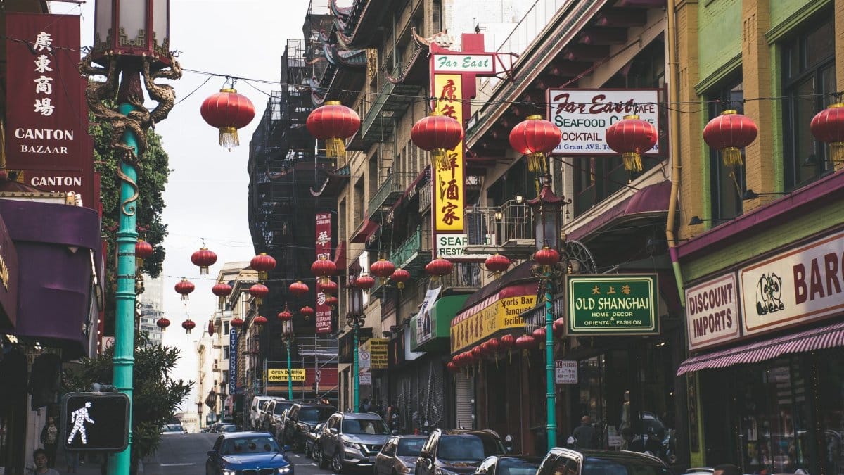 Bustling San Francisco Chinatown street with red lanterns and shops, capturing urban vibrancy.