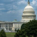 Iconic view of the United States Capitol Building surrounded by lush greenery on a sunny day.