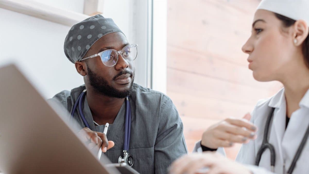 Two healthcare workers in conversation, focusing on collaboration and patient care.