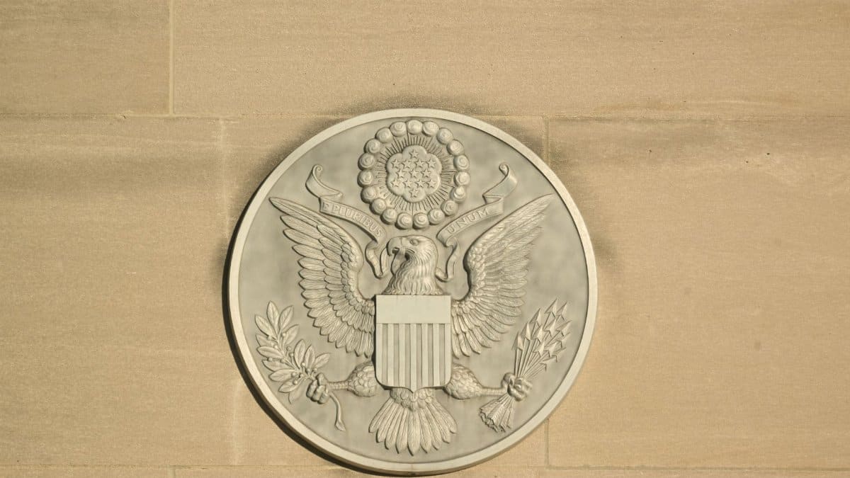 Stone carving of the Great Seal of the United States on a wall displaying an eagle with shield and olive branch.