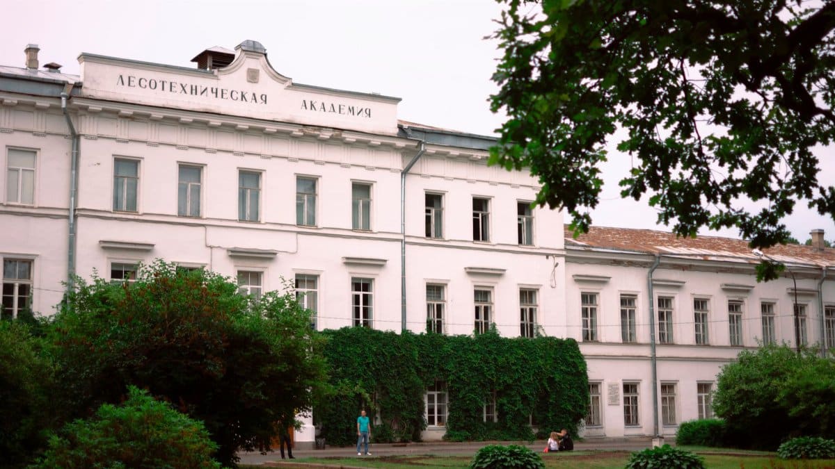 Classic architecture of the Lesotechnic Academy building with lush greenery in Saint Petersburg, Russia.