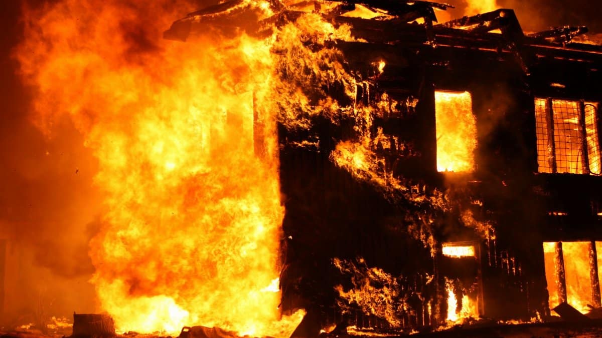 Intense flames consume a building in a dramatic nighttime fire scene.