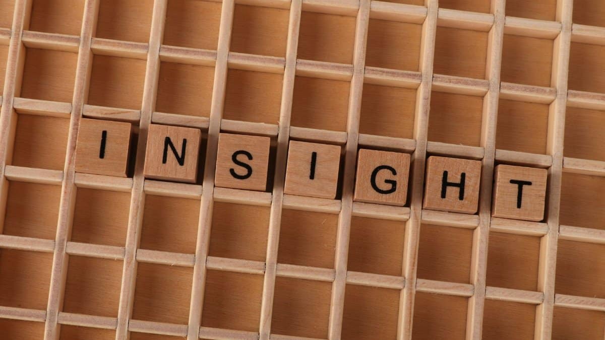 Wooden Scrabble letters spelling 'INSIGHT' on a wooden grid creating a conceptual image.