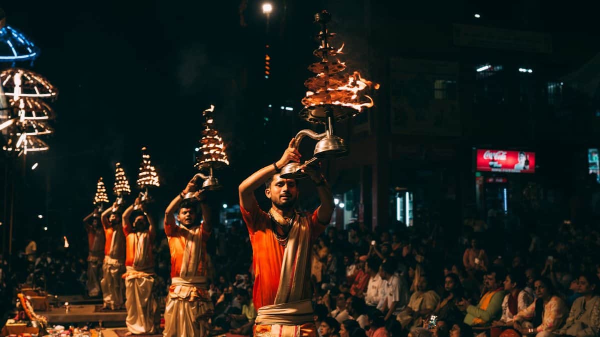 A mesmerizing view of the Ganga Aarti ceremony with priests performing rituals on the ghats of Varanasi at night.