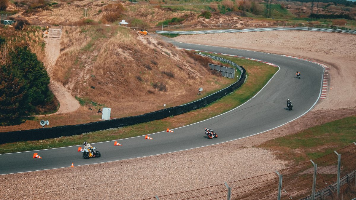 Motorcycles speeding through a curved track during a thrilling racing event outdoors.