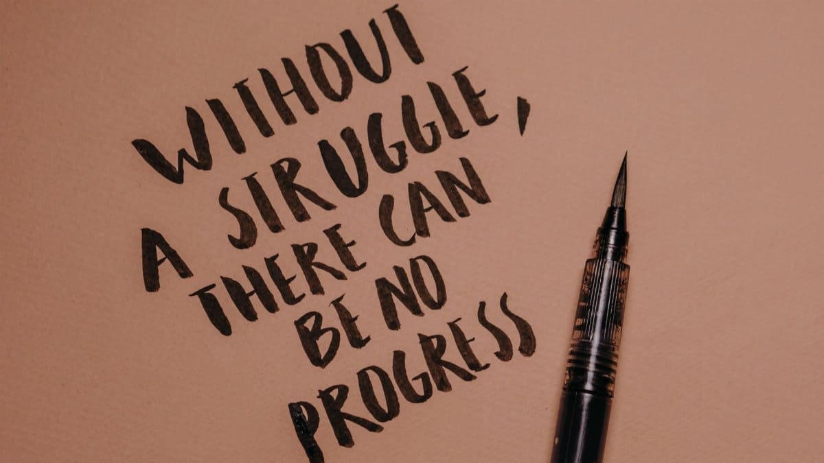Handwritten motivational quote using a brush pen on a textured background for inspiration.