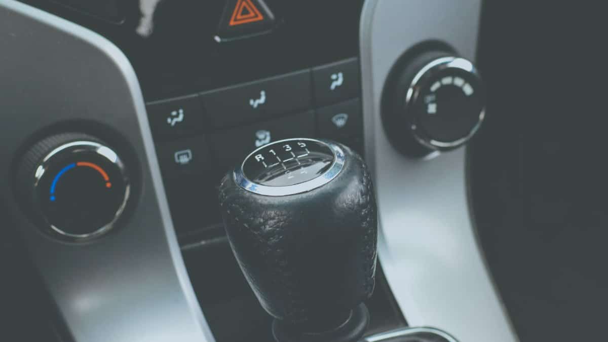Detailed view of a manual gear shift knob and car console interior.