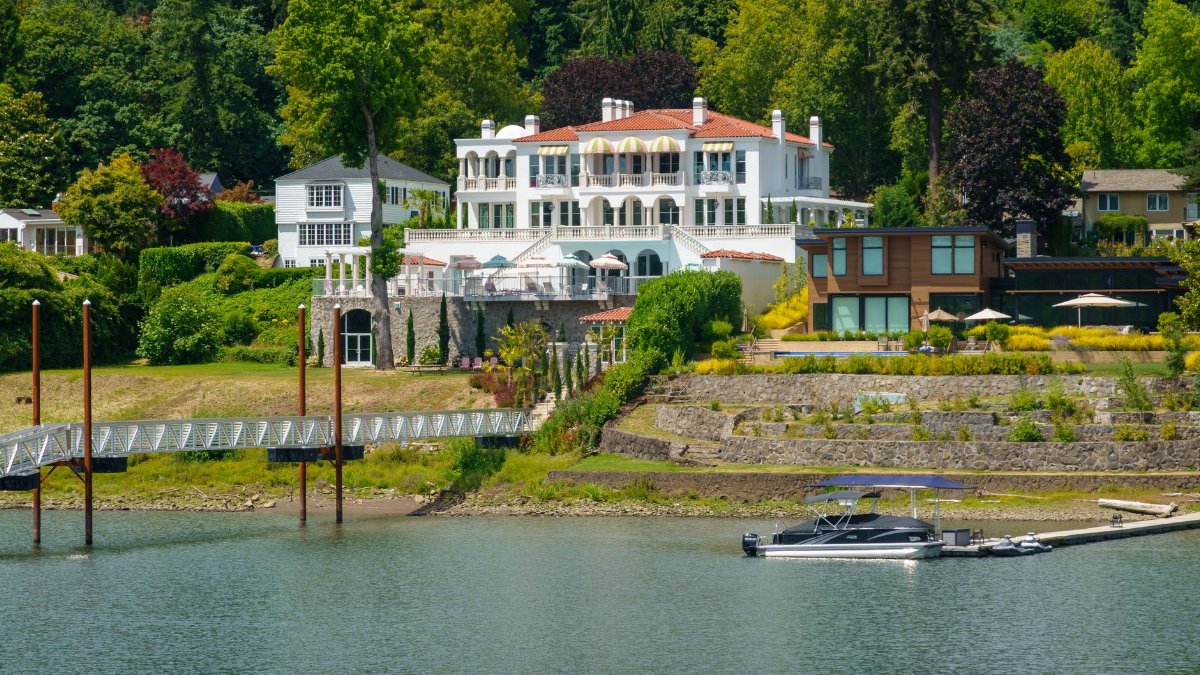 Stunning villa by the waterfront with lush greenery, perfect for luxury and relaxation.