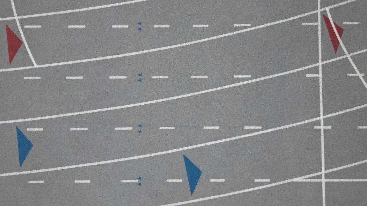 Geometric aerial shot of a sports track with colorful lane markings.