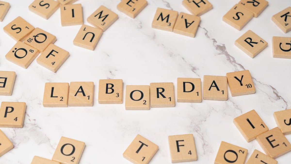 Labor Day spelled with Scrabble tiles on a marble surface, symbolizing celebration and creativity.