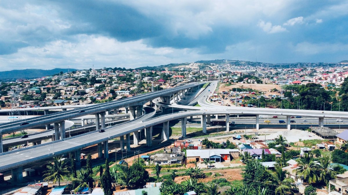 A stunning aerial view of Kwabenya with its highway and vibrant cityscape under a cloudy sky in Ghana.