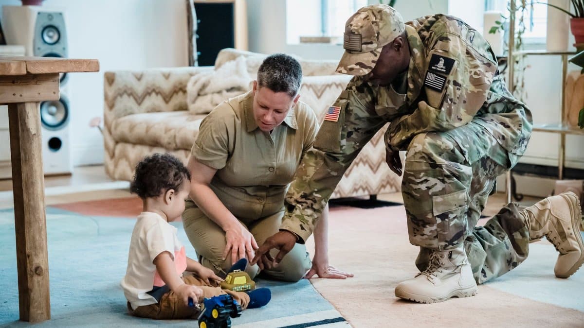 A family shares quality time as a military parent engages with a child indoors.