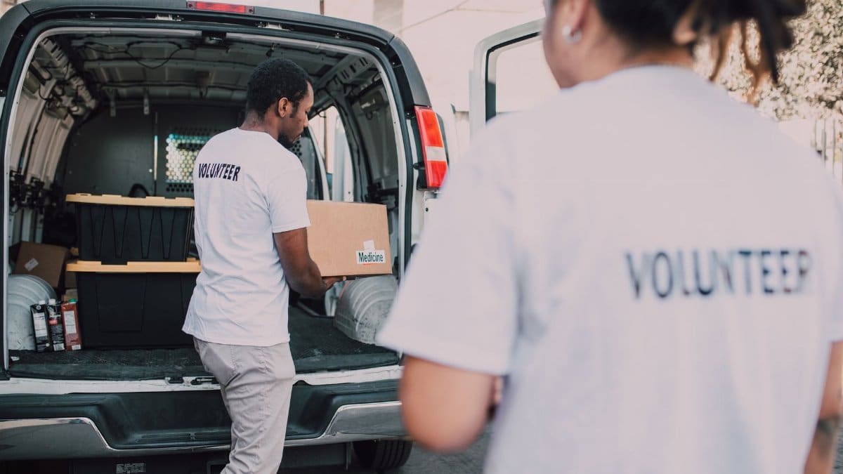 Volunteers loading medicine supplies into a van for donation and distribution.