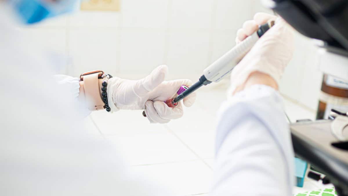 A medical professional using pipette in a lab setting, emphasizing precision and care.
