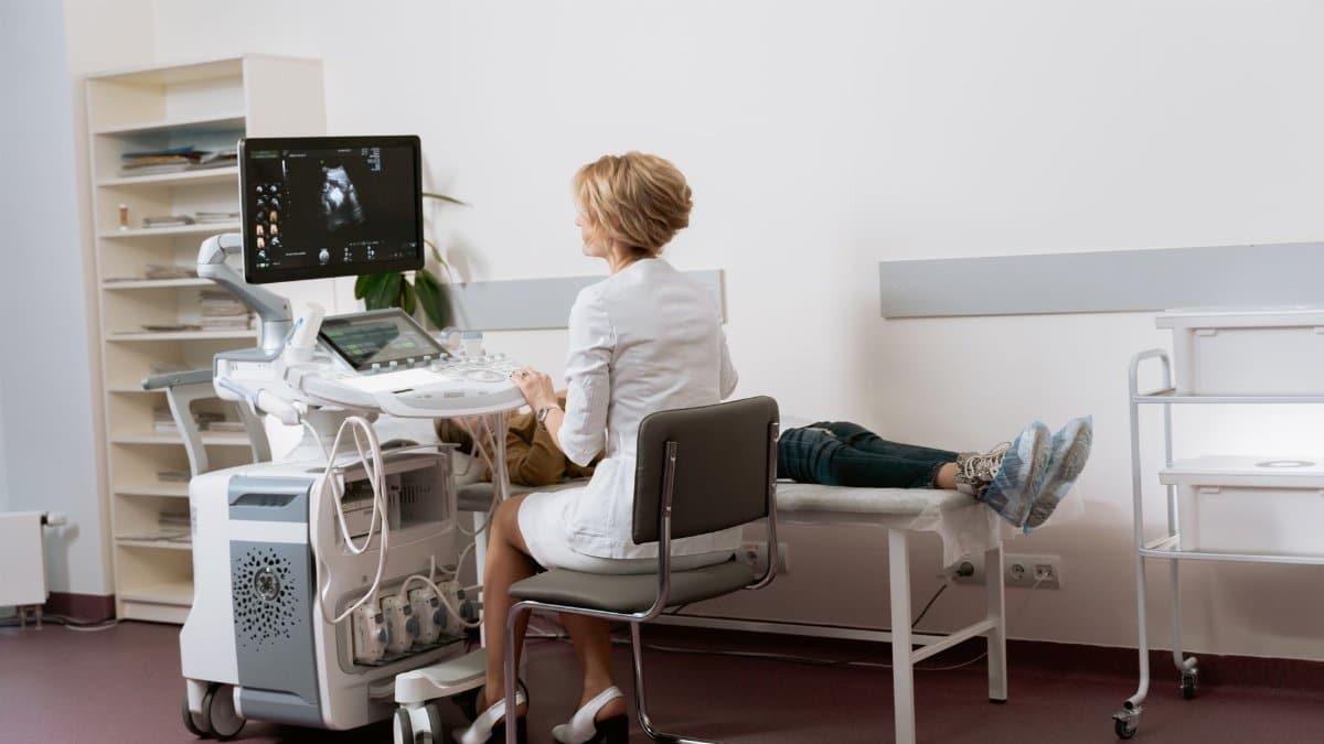 Doctor performing ultrasound scan on patient in modern clinic.