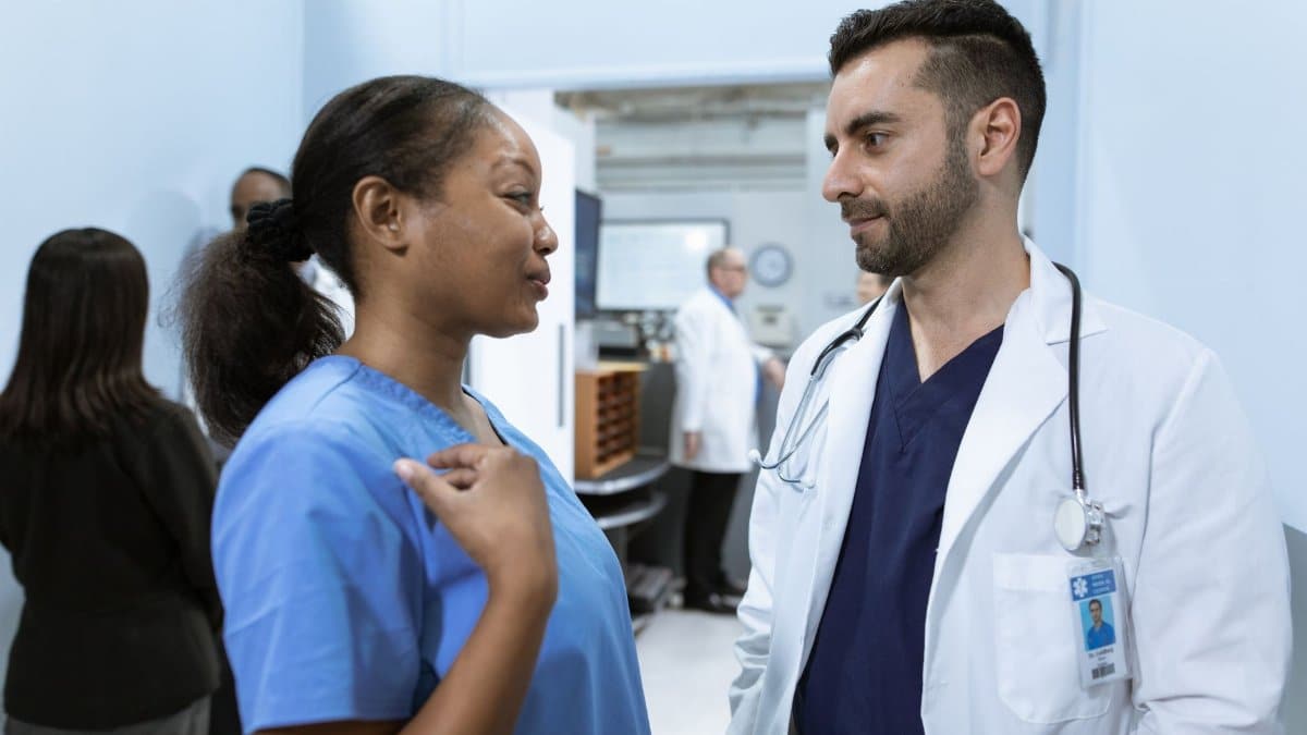 Medical professionals discussing patient care in a hospital hallway.