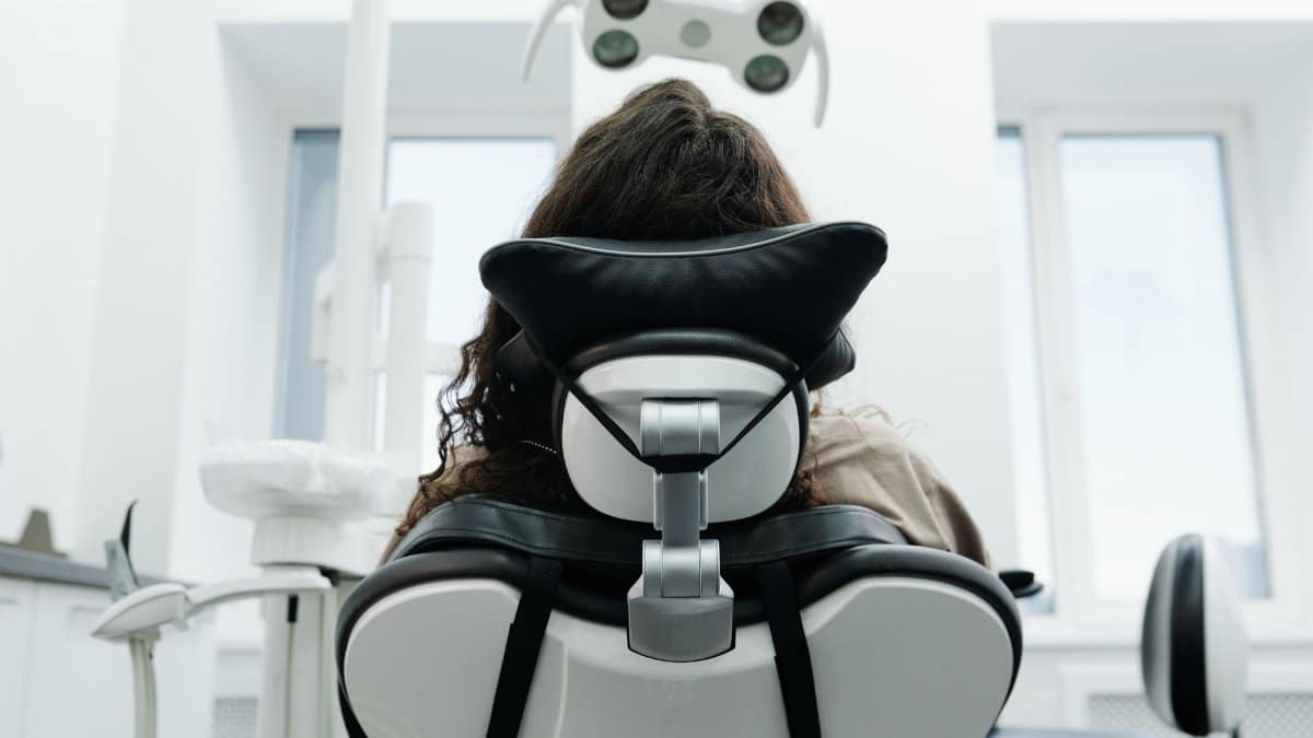 Patient sitting in a dental chair inside a modern clinic, ready for an examination.