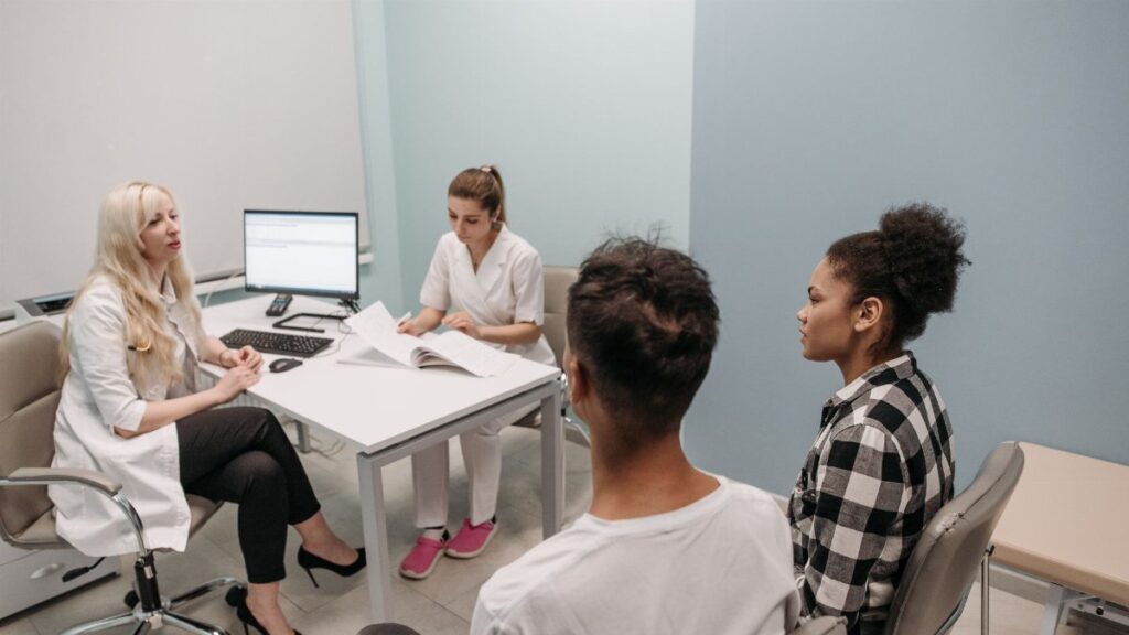 Doctor and patients during a consultation in a modern clinic, teamwork concept.