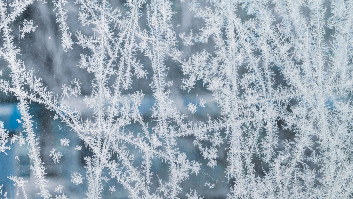 Close-up view of delicate frost patterns on a window capturing winter's icy beauty.