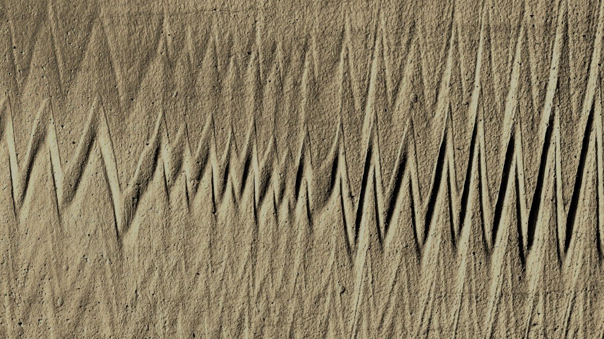 Concrete surface with zigzag patterns creating an abstract art texture.