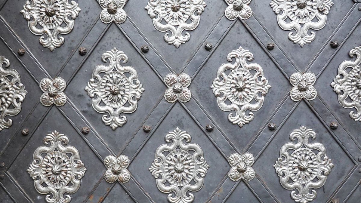 Close-up of an ornate iron door showcasing intricate historical patterns.