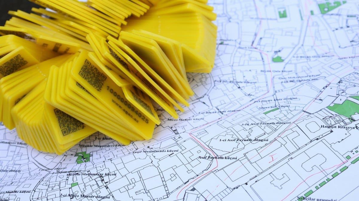 Stack of yellow QR code markers placed on a detailed map for location tracking and navigation.