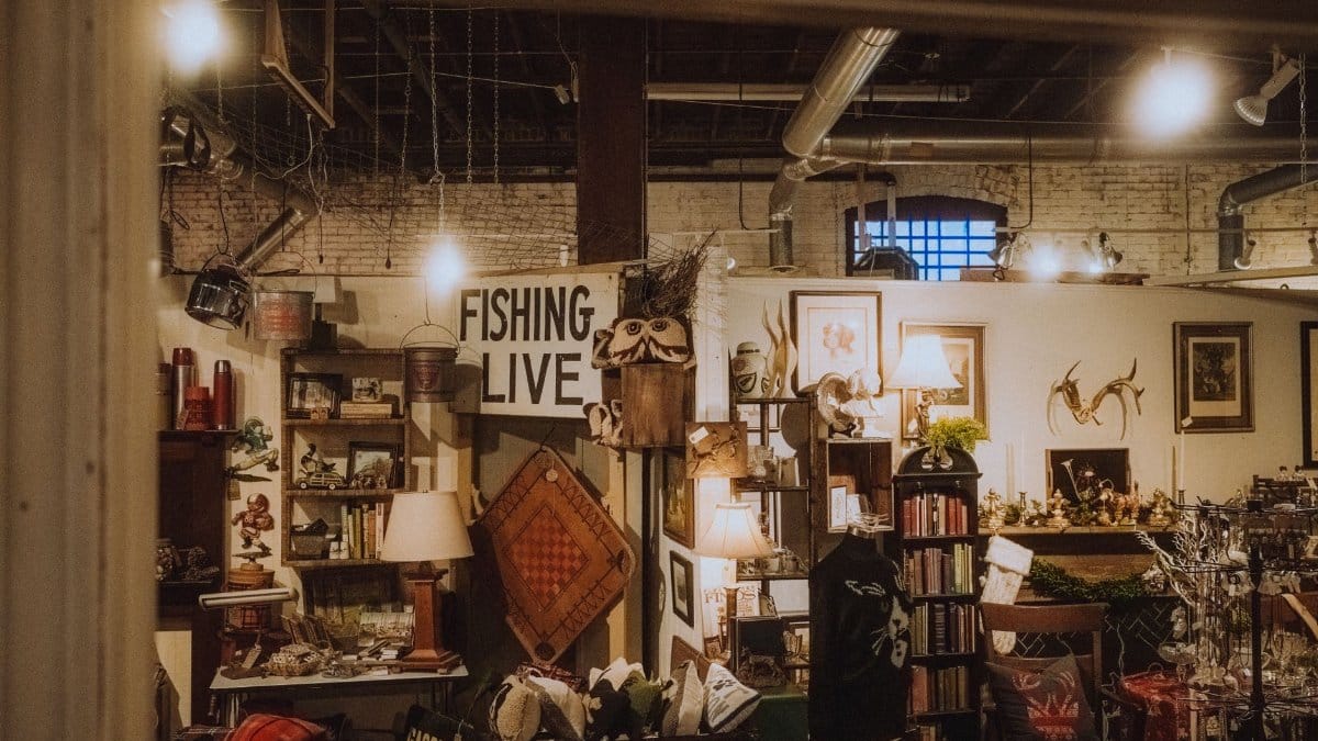 Warmly lit vintage shop interior with eclectic antiques and decor, offering a nostalgic and cozy atmosphere.