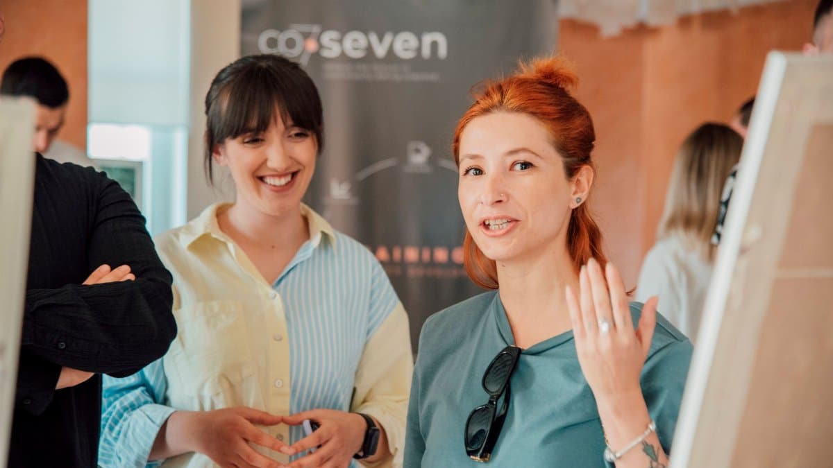 Two women engaging in a lively discussion during a workshop session indoors.
