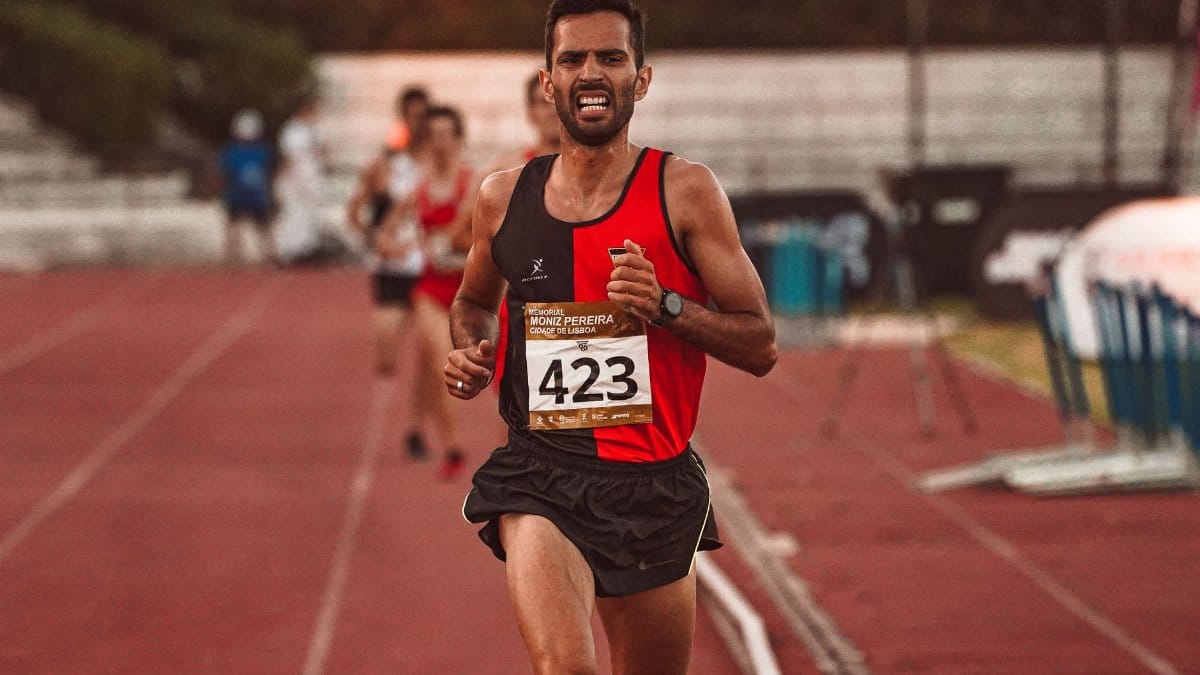 Focused male athlete competing in track race, showing determination and endurance.