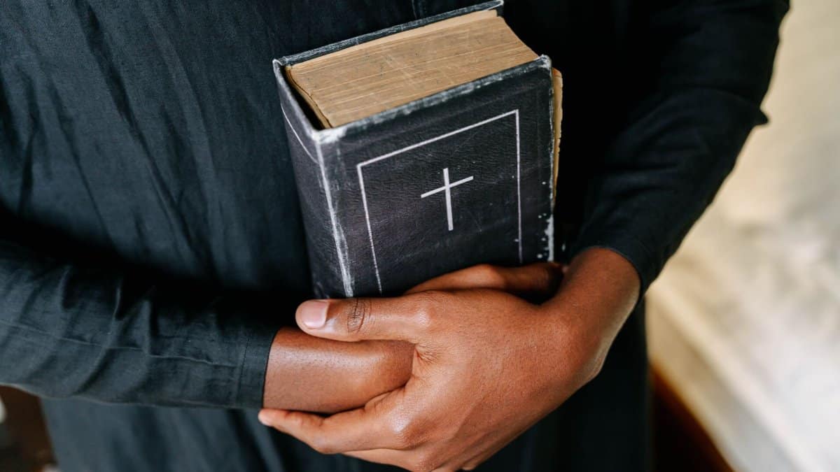 Person holding a Holy Bible, symbolizing faith and spirituality.