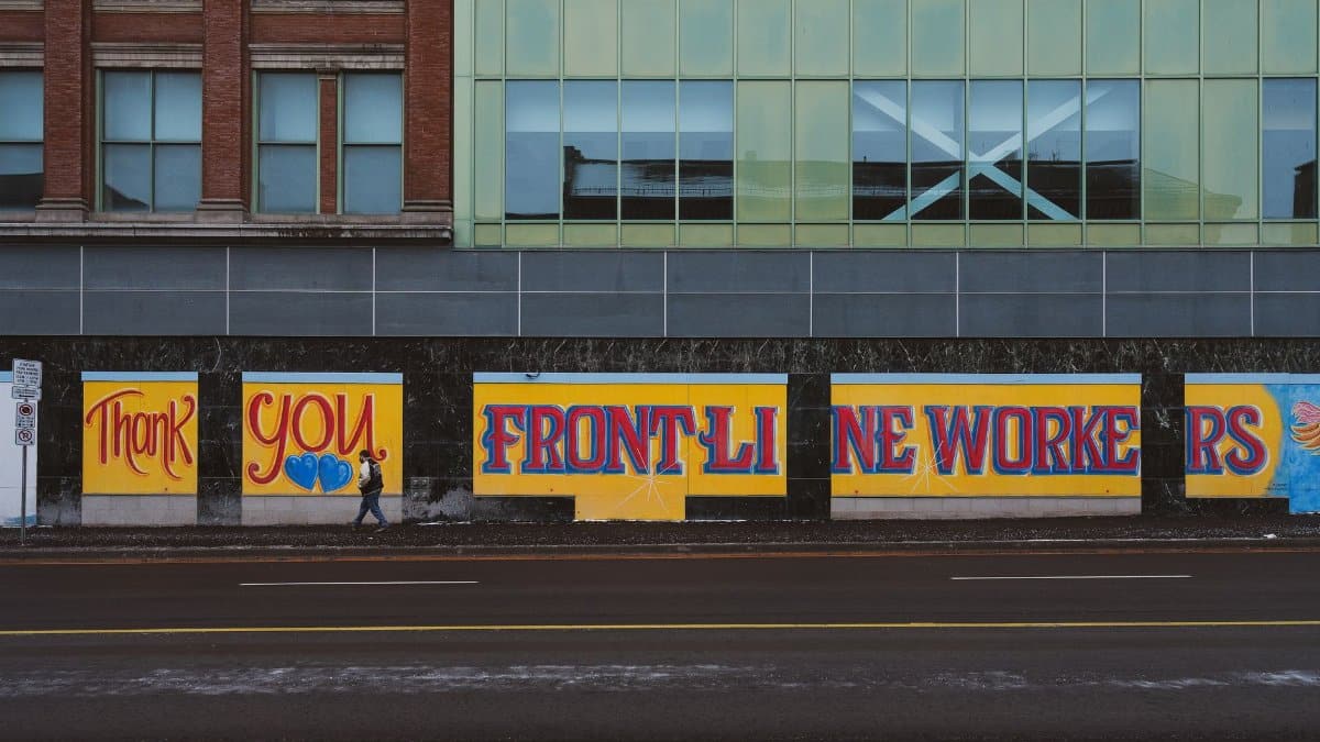 Vibrant mural honoring front-line workers on a city street wall in London, Ontario.