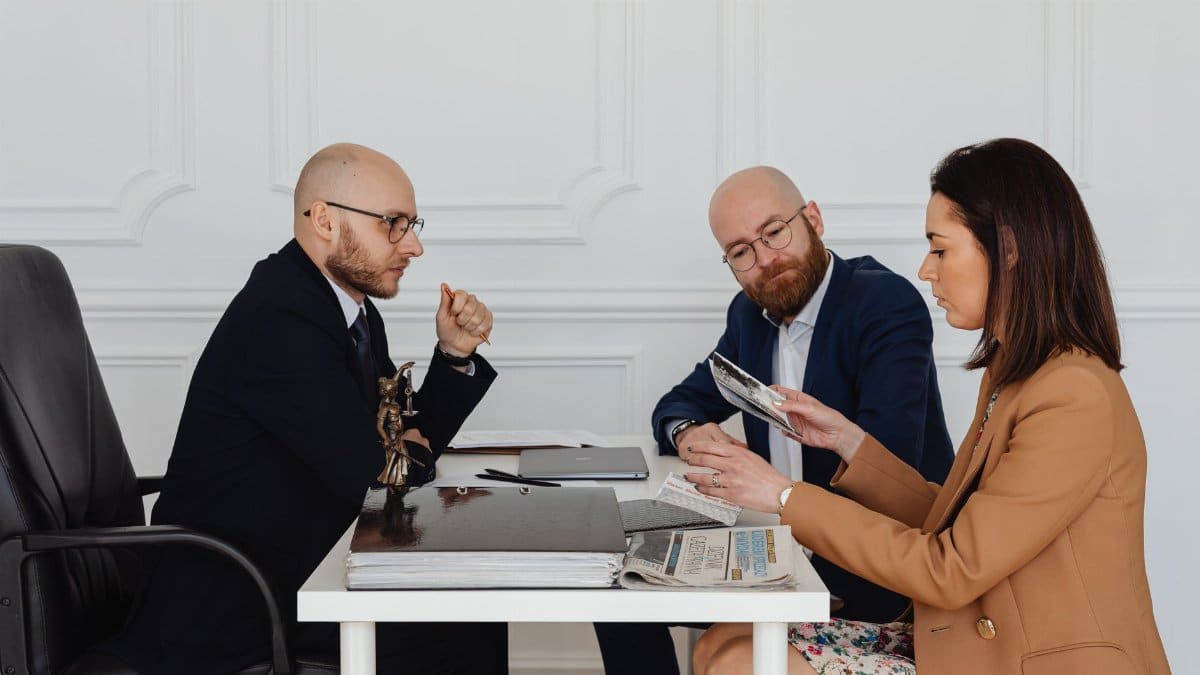 A group of professionals discussing and reviewing documents in an office setting.