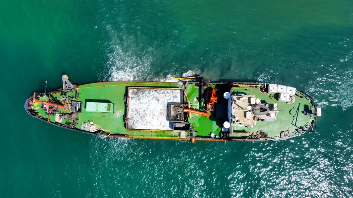 Aerial shot of a cargo ship on the ocean, showcasing shipping and marine transport.