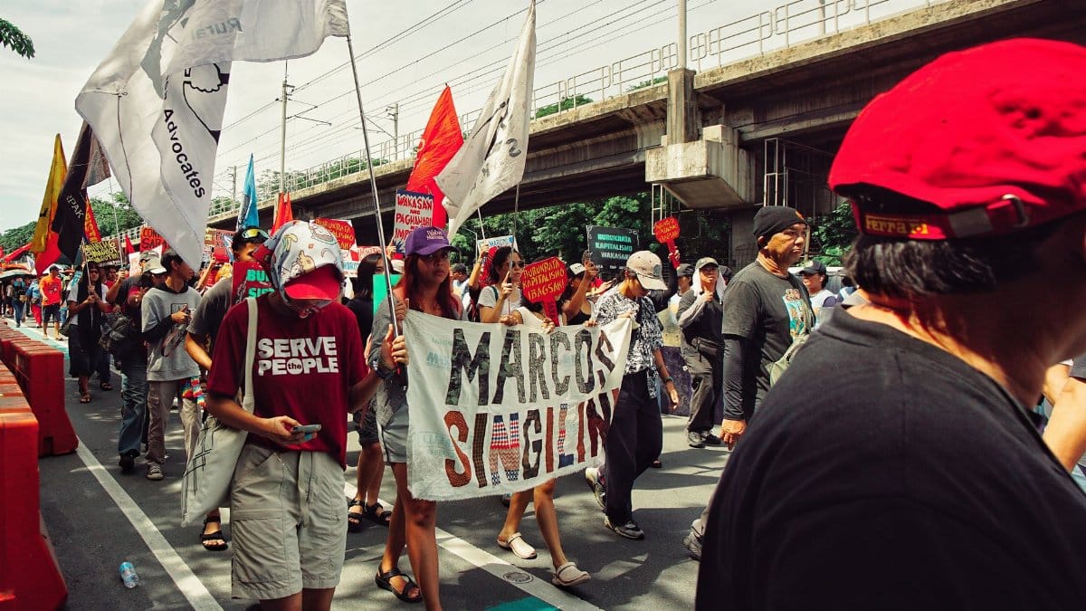 A group of people in a political rally with banners and flags showing social and political activism.