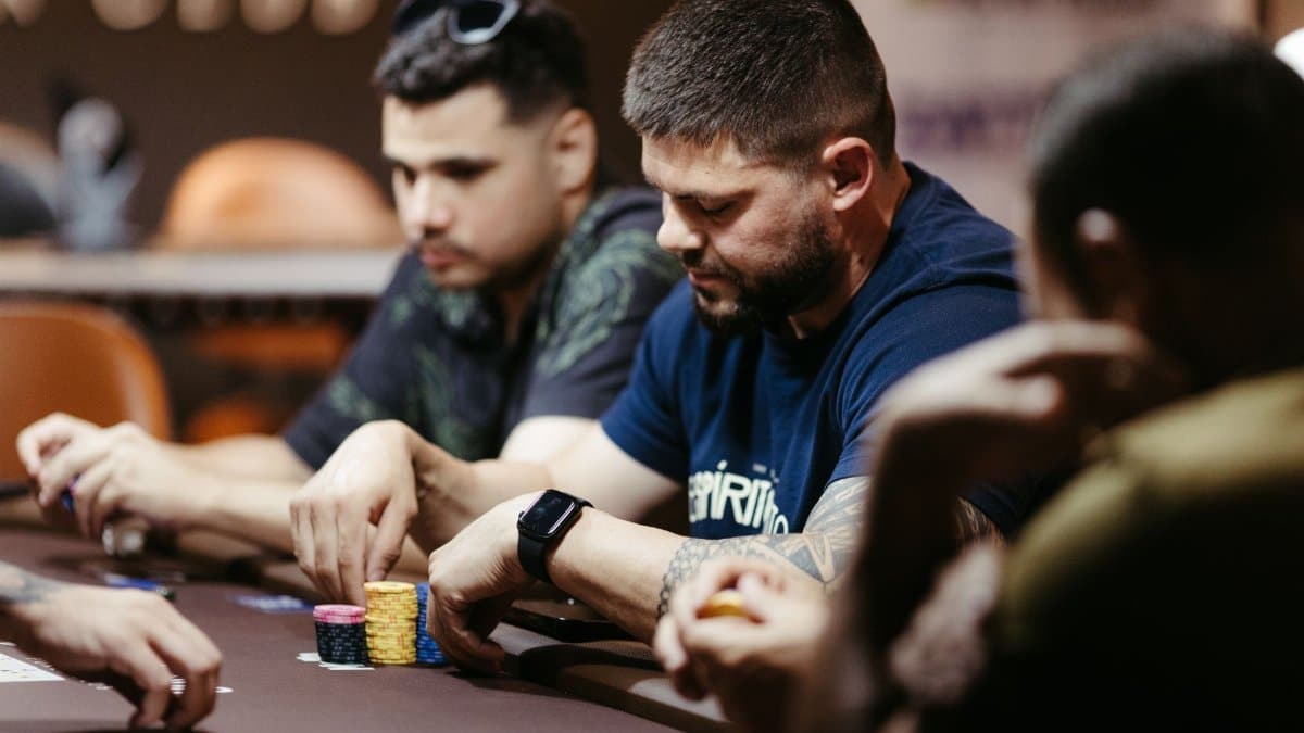 Players focused on a poker game at a casino table, showcasing intense strategies and concentration.