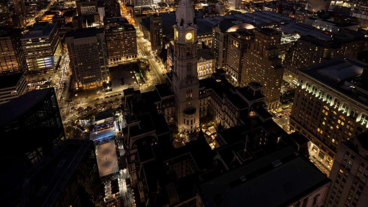 A stunning aerial view of Philadelphia cityscape featuring City Hall illuminated at night.