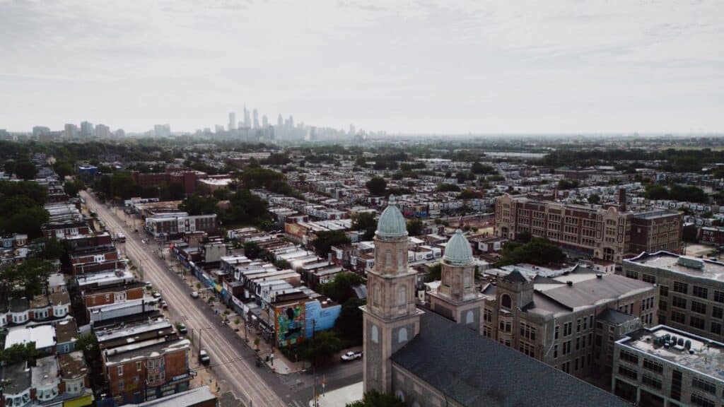 Aerial view showcasing Philadelphia's skyline and urban landscape with a historic church in the foreground.