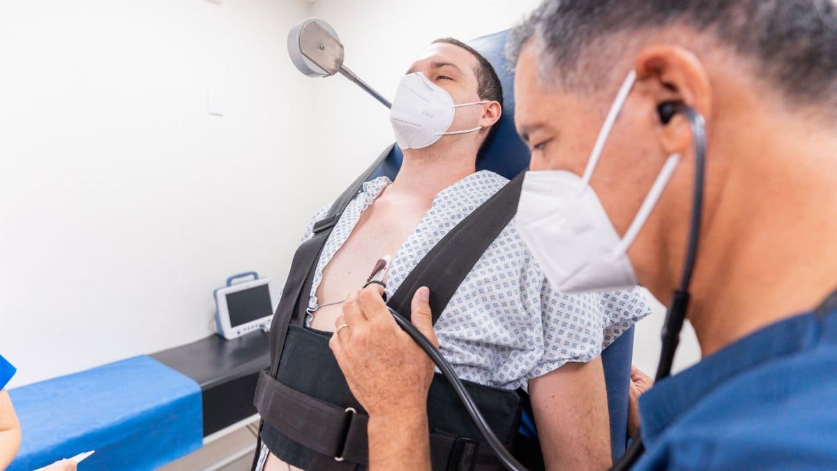 A medical practitioner conducts a chest examination on a patient using a stethoscope in a clinical setting.