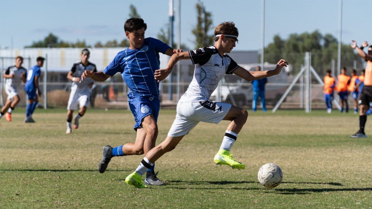 Two soccer players in action during an outdoor match, showcasing skill and speed.