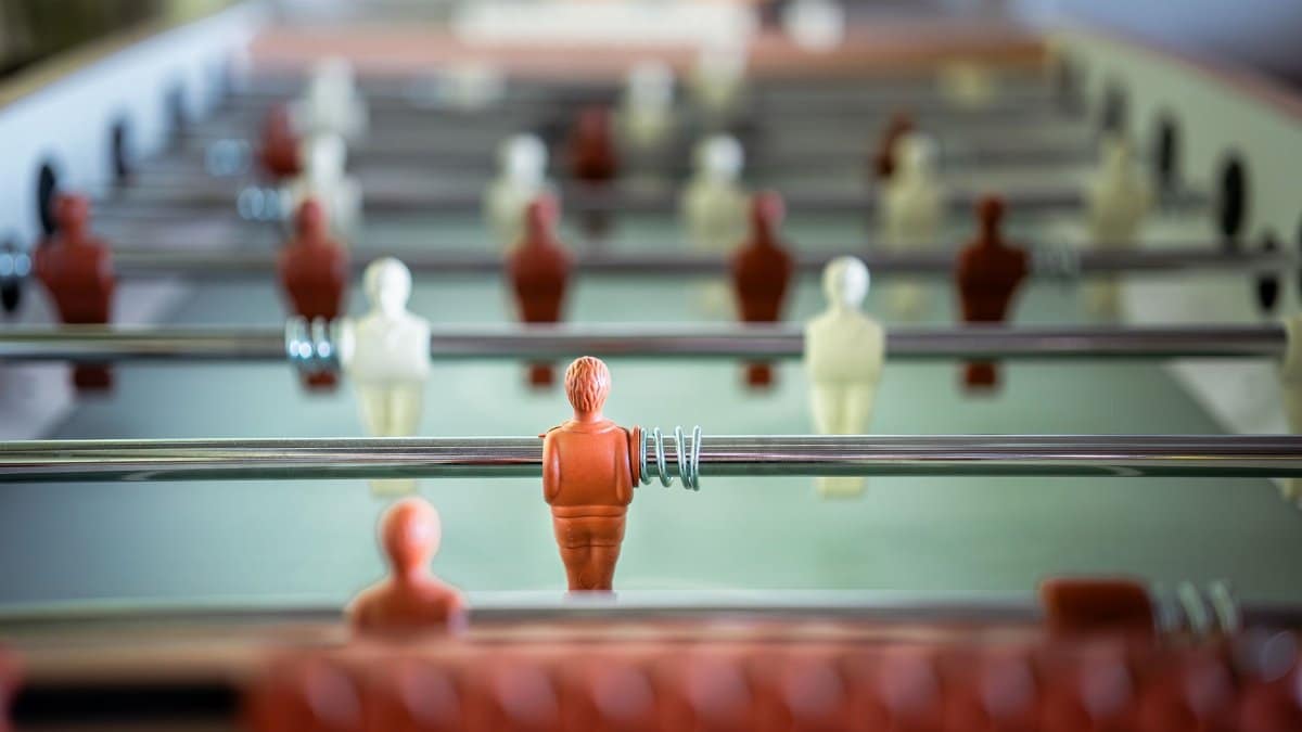 Detailed view of a foosball table with focus on player figurine, highlighting fun and strategic gameplay.