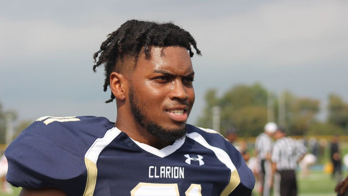Portrait of a determined football player wearing a Clarion jersey on the field.