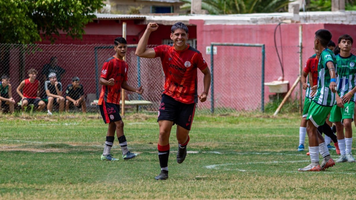 Teen soccer player celebrates on the field during an outdoor match game.